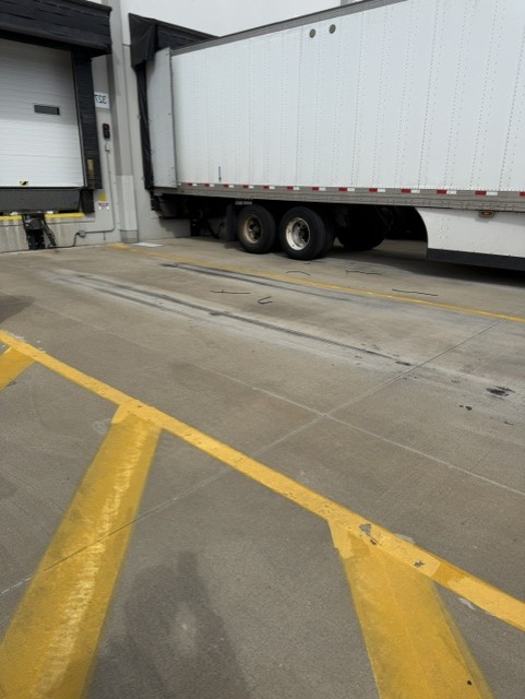Trailer parked at dock door with painted lot striping